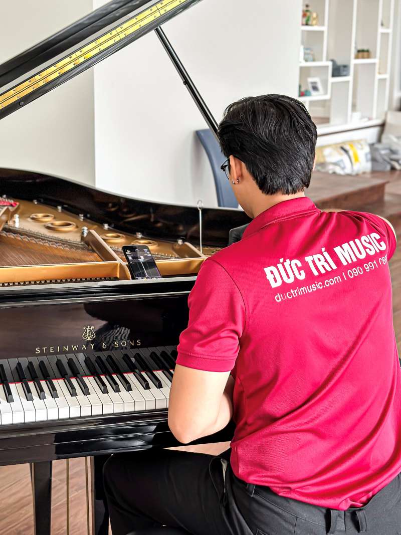 Dịch vụ lên dây đàn Piano chuyên nghiệp, uy tín tại TPHCM kèm bảng giá 2025 - Piano Đức Trí 2 Hình ảnh nhân viên của Piano Đức Trí đang chỉnh sửa dây đàn Piano